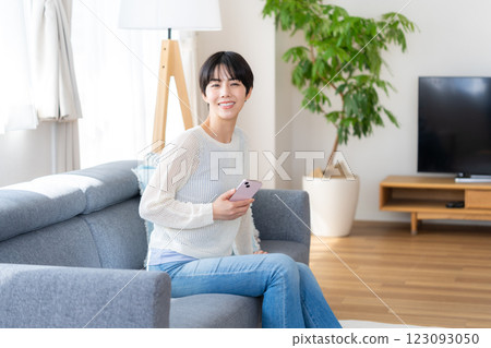 A woman who operates a smartphone in the room 123093050