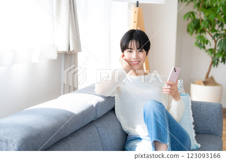 A woman who operates a smartphone in the room 123093166