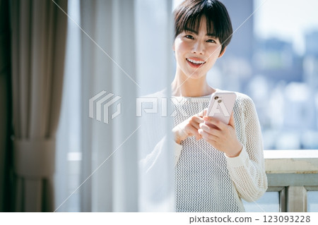 A woman who operates a smartphone in the room 123093228
