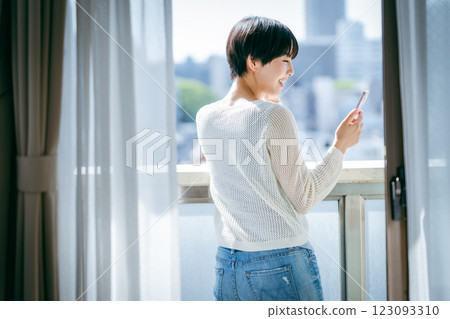 A woman who operates a smartphone in the room A woman who operates a smartphone in the room 123093310