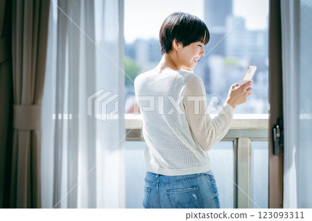 A woman who operates a smartphone in the room A woman who operates a smartphone in the room 123093311