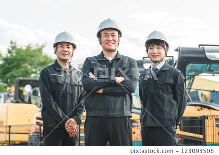 A male businessman working in the construction and building industry in work clothes in front of heavy machinery 123093508