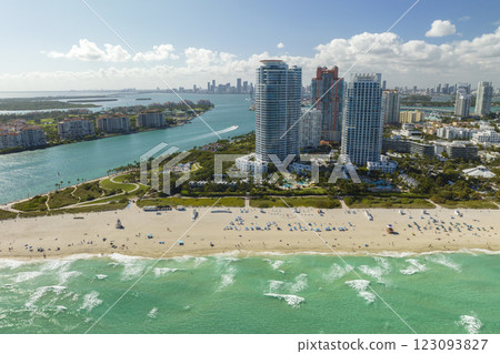 Tourism infrastructure in southern USA. South Beach sandy surface with tourists relaxing on hot Florida sun. Miami Beach city with high luxury hotels and condos 123093827
