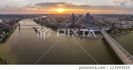 Sunset urban landscape of downtown district of Cincinnati city in Ohio, USA. Skyline with bridge traffic and brightly illuminated high skyscraper buildings in modern American megapolis 123093856