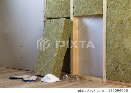 Rock wool and fiberglass insulation staff material for cold barrier. Tools for work with glass wool: protective goggles, glasses and mask. Warm home, economy, construction and renovation concept. 123094056
