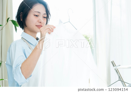 一名婦女將衣服掛在室內晾乾 123094154