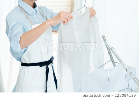 一名婦女將衣服掛在室內晾乾 123094159