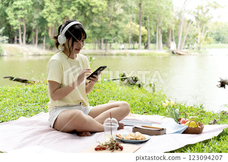 teenage girl is sitting happily relaxing and listening to music with headphones 123094207