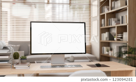 A close-up of white screen computer on the wooden table with decorative items in study room. 123094281