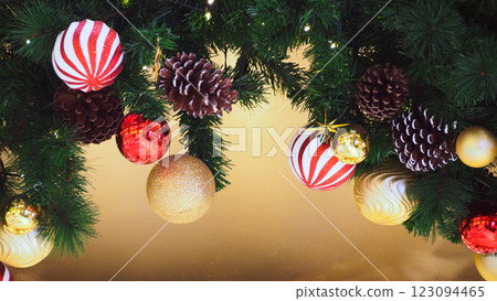 A beautifully decorated Christmas garland with red, gold ornaments, and pinecones. Ideal for holiday-themed designs and festive decorations 123094465