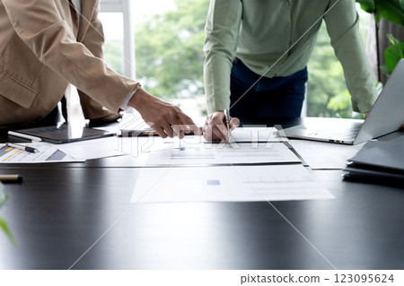 A group of executives is working together to look at various information  consider 123095624