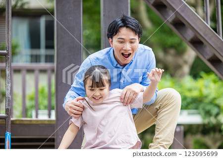 Parent and child playing in the park 123095699