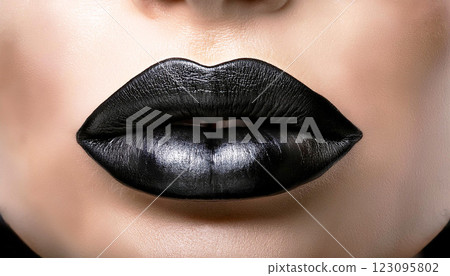 lips, Close up of glossy black lips with a metallic texture, tightly sealed, symbolizing silence and mystery, set against a clean white background for a bold artistic statement 123095802