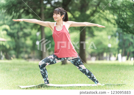 A woman doing yoga in the park (park yoga, outdoor yoga, health) 123095883