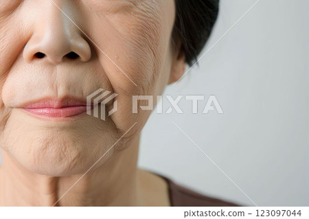 Elderly women who are troubled by wrinkles, sagging skin, and age spots around the mouth (ptosis, swelling under the eyes, cosmetic surgery, rejuvenation) 123097044