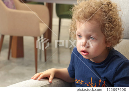Little boy of 3- years old watching cartoon in room closely. Kids and lifestyle. Emotional intelligence.  123097608