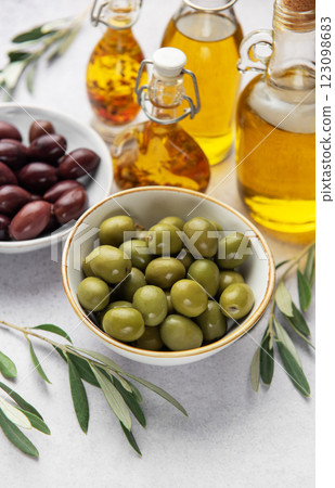 Bowls of green and black olives with olive oil bottles and olive branches 123098683