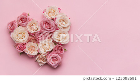Heart of roses forming a romantic symbol on pink background 123098691