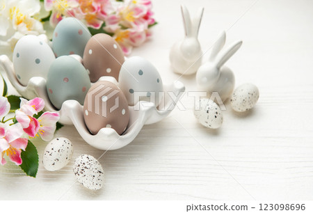 Easter eggs with spring flowers and ceramic bunnies celebrating easter sunday 123098696