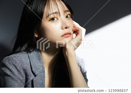 A shadowy and atmospheric portrait of a young woman wearing a jacket 123098837