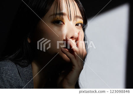 一位身穿夾克的年輕女子的陰暗而有氣氛的肖像 一位身穿夾克的年輕女子的陰暗而有氣氛的肖像 123098846
