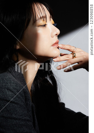 A shadowy and atmospheric portrait of a young woman wearing a jacket 123098858