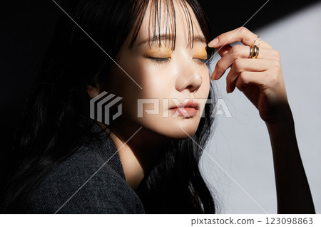 A shadowy and atmospheric portrait of a young woman wearing a jacket 123098863