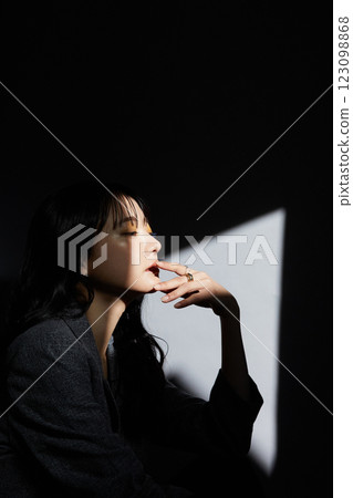 一位身穿夾克的年輕女子的陰暗而有氣氛的肖像 123098868