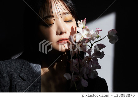 A shadowy and atmospheric portrait of a young woman wearing a jacket 123098870