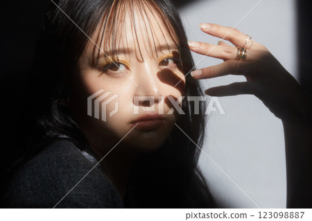 一位身穿夾克的年輕女子的陰暗而有氣氛的肖像 一位身穿夾克的年輕女子的陰暗而有氣氛的肖像 123098887