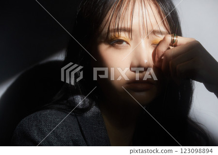 一位身穿夾克的年輕女子的陰暗而有氣氛的肖像 一位身穿夾克的年輕女子的陰暗而有氣氛的肖像 123098894