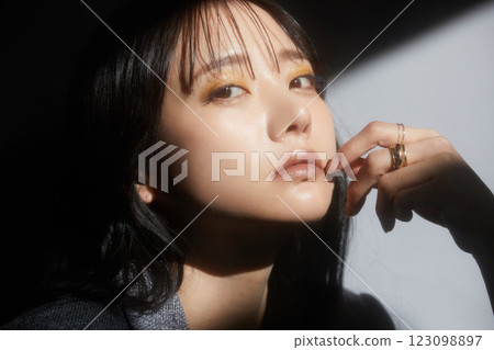 A shadowy and atmospheric portrait of a young woman wearing a jacket 123098897