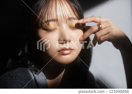 A shadowy and atmospheric portrait of a young woman wearing a jacket 123098898