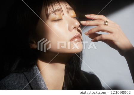 A shadowy and atmospheric portrait of a young woman wearing a jacket A shadowy and atmospheric portrait of a young woman wearing a jacket 123098902