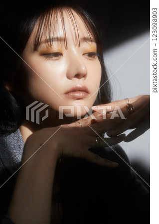 A shadowy and atmospheric portrait of a young woman wearing a jacket 123098903