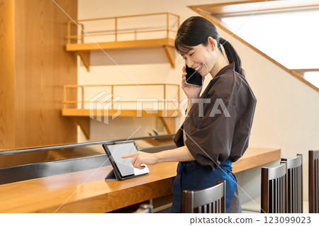 Restaurant employee managing using a tablet 123099023