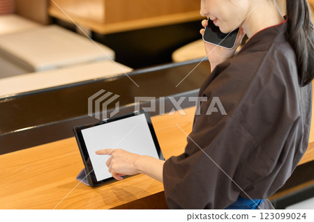 Restaurant employee managing using a tablet 123099024
