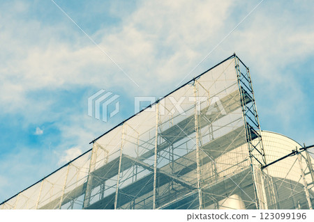Scaffolding on a building undergoing repair work, emphasizing warm and cool colors Scaffolding on a building undergoing repair work, emphasizing warm and cool colors 123099196