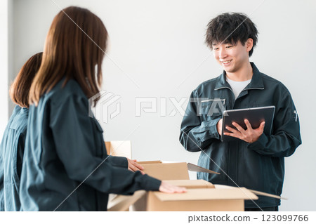 A worker of a transportation, logistics, courier, distribution, delivery, or delivery company packing packages into cardboard boxes 123099766