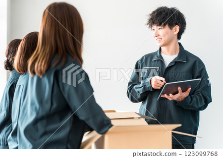 A worker of a transportation, logistics, courier, distribution, delivery, or delivery company packing packages into cardboard boxes 123099768