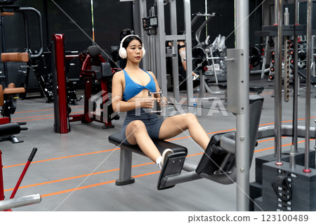young woman exercising in the gym using tools 123100489