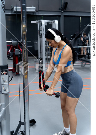 Young asian woman is standing and exercising on a standing exercise machine Young asian woman is standing and exercising on a standing exercise machine 123100493