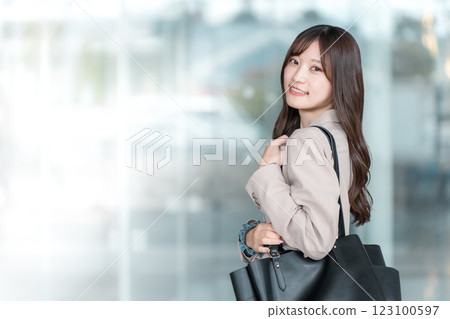 年輕的亞洲女商人在城市的辦公區散步 年輕的亞洲女商人在城市的辦公區散步 123100597