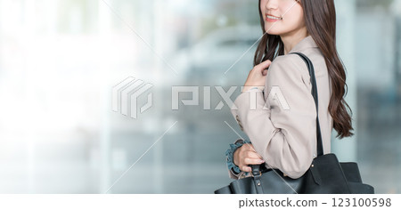 年輕的亞洲女商人在城市的辦公區散步 123100598