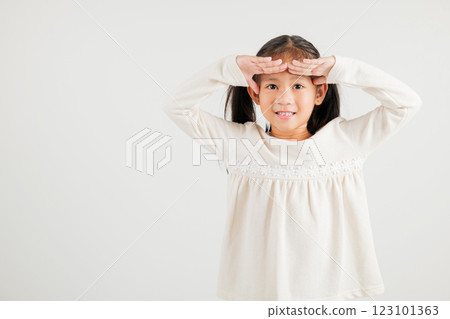 Searching concept. Asian young girl kid looking far away with hand over head at studio shot isolated on white background, Portrait of Happy kindergarten child looking at distance with eyes shaded 123101363