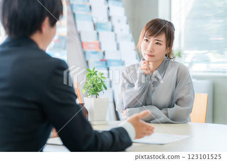 A woman who came to consult about insurance and a male businessman who serves her A woman who came to consult about insurance and a male businessman who serves her 123101525