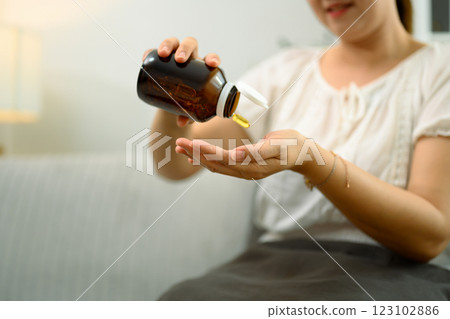 Close up shot of middle aged woman taking fish oil supplements for health and wellness Close up shot of middle aged woman taking fish oil supplements for health and wellness 123102886