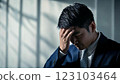 A businessman in a suit worried with his hand on his forehead 123103464
