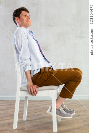Young guy office worker doing exercises on chair Young guy office worker doing exercises on chair 123104475