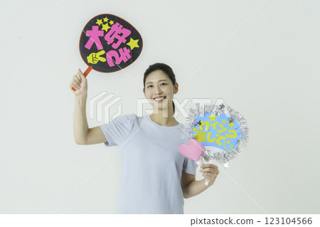 Oshikatsu: A young woman cheering on her idol with a fan on a white background Oshikatsu: A young woman cheering on her idol with a fan on a white background 123104566